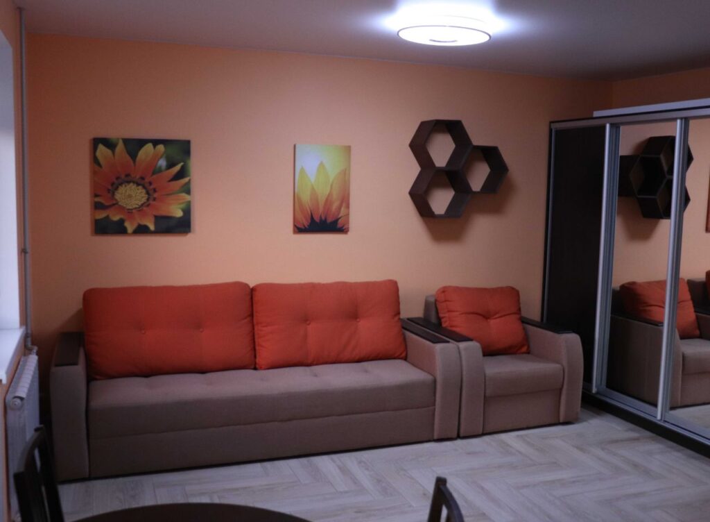 Fertiges Wohnzimmer mit Sofa, Bodenbelag und Wandgestaltung nach der Renovierung