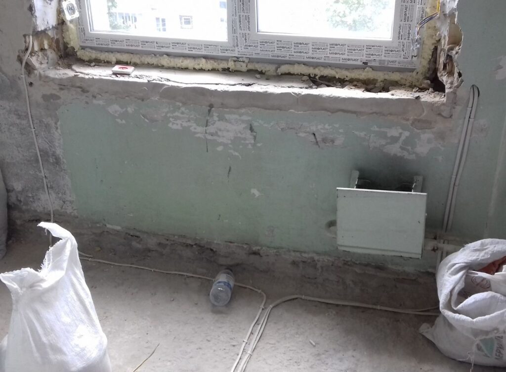 Fensterbereich mit Heizkörper und Elektrovorbereitung während der Renovierung